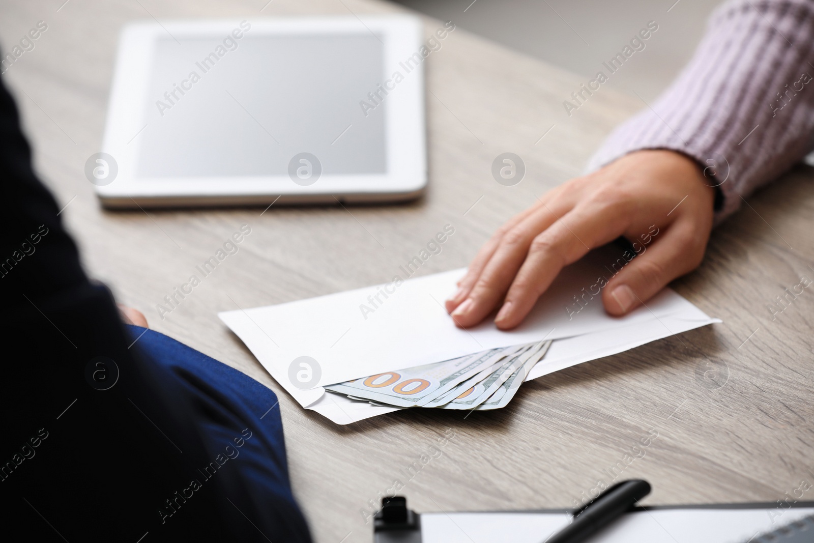 Photo of Woman offering bribe money at table, closeup