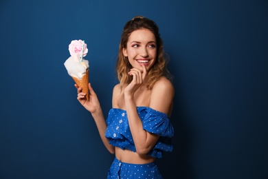 Photo of Portrait of young woman holding cotton candy dessert on blue background