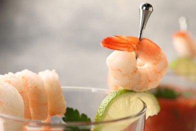 Photo of Tasty shrimp cocktail with sauce in glass on blurred background, closeup