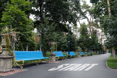 Image of Beautiful view of park with word Start and blue wooden benches