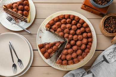 Photo of Delicious tiramisu cake and coffee beans on wooden table, flat lay