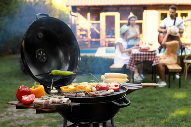 Photo of Barbecue grill with meat and vegetables outdoors