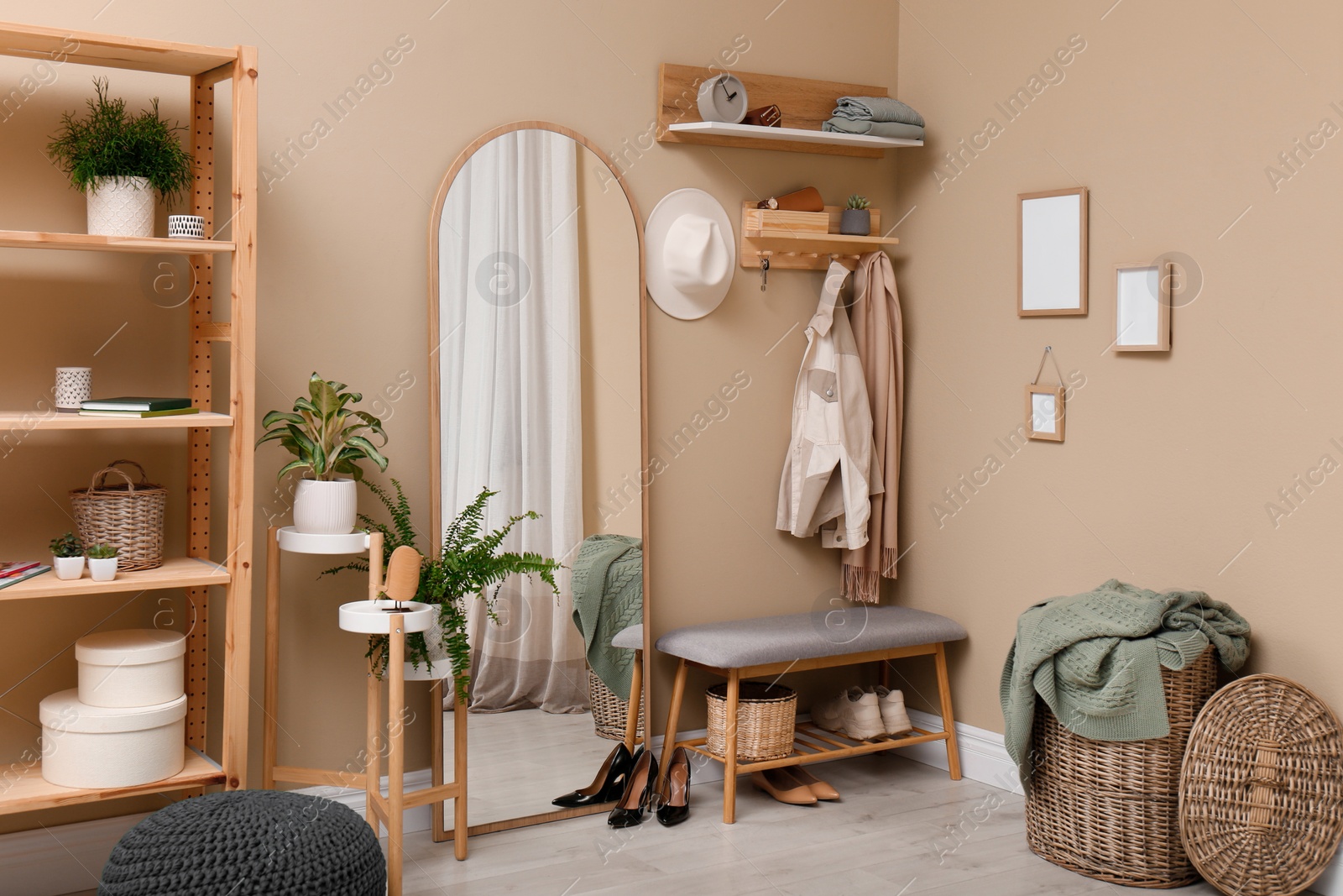 Photo of Hallway interior with stylish furniture, accessories and wooden hanger for keys on beige wall