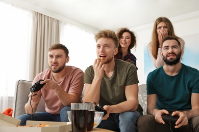 Emotional friends playing video games at home