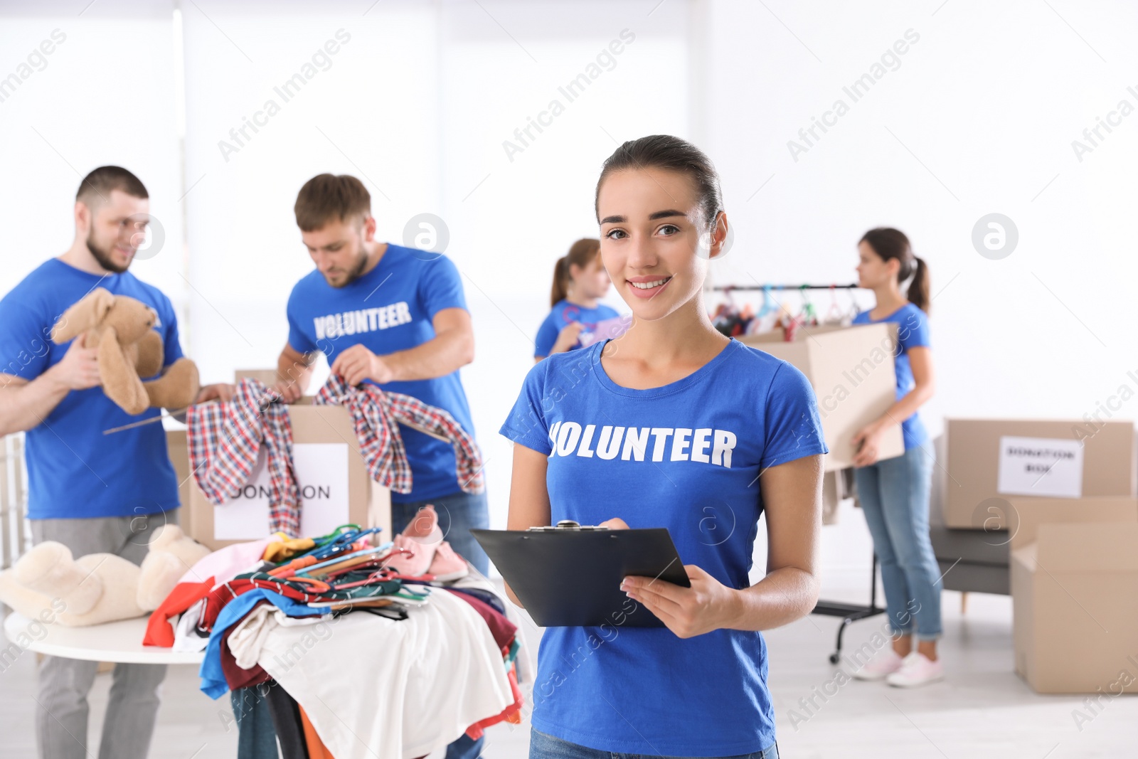 Photo of Female volunteer with clipboard listing donations indoors