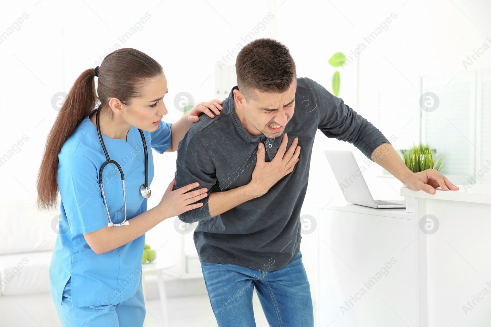 Photo of Young man having heart attack in clinic