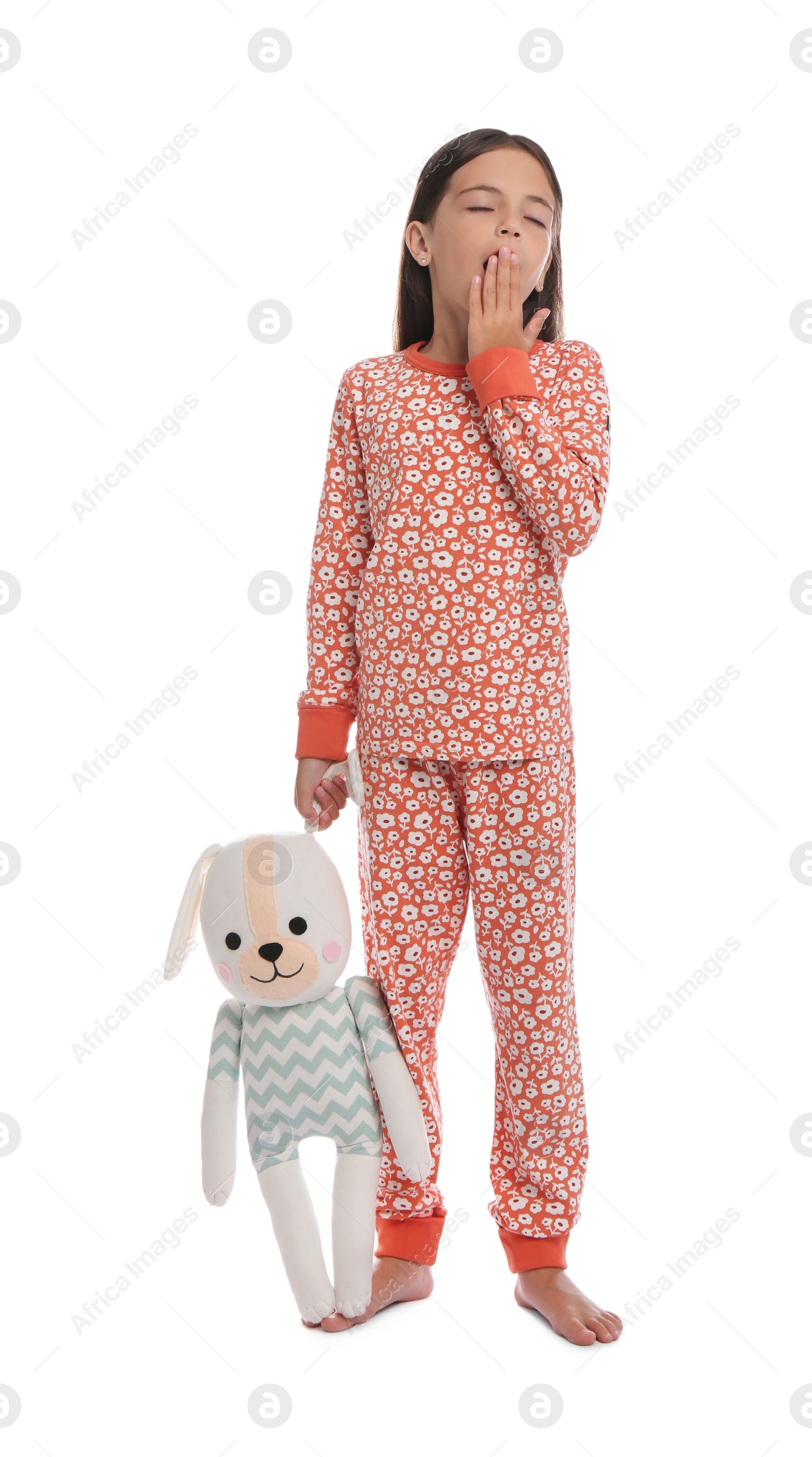 Photo of Cute girl wearing pajamas with toy on white background