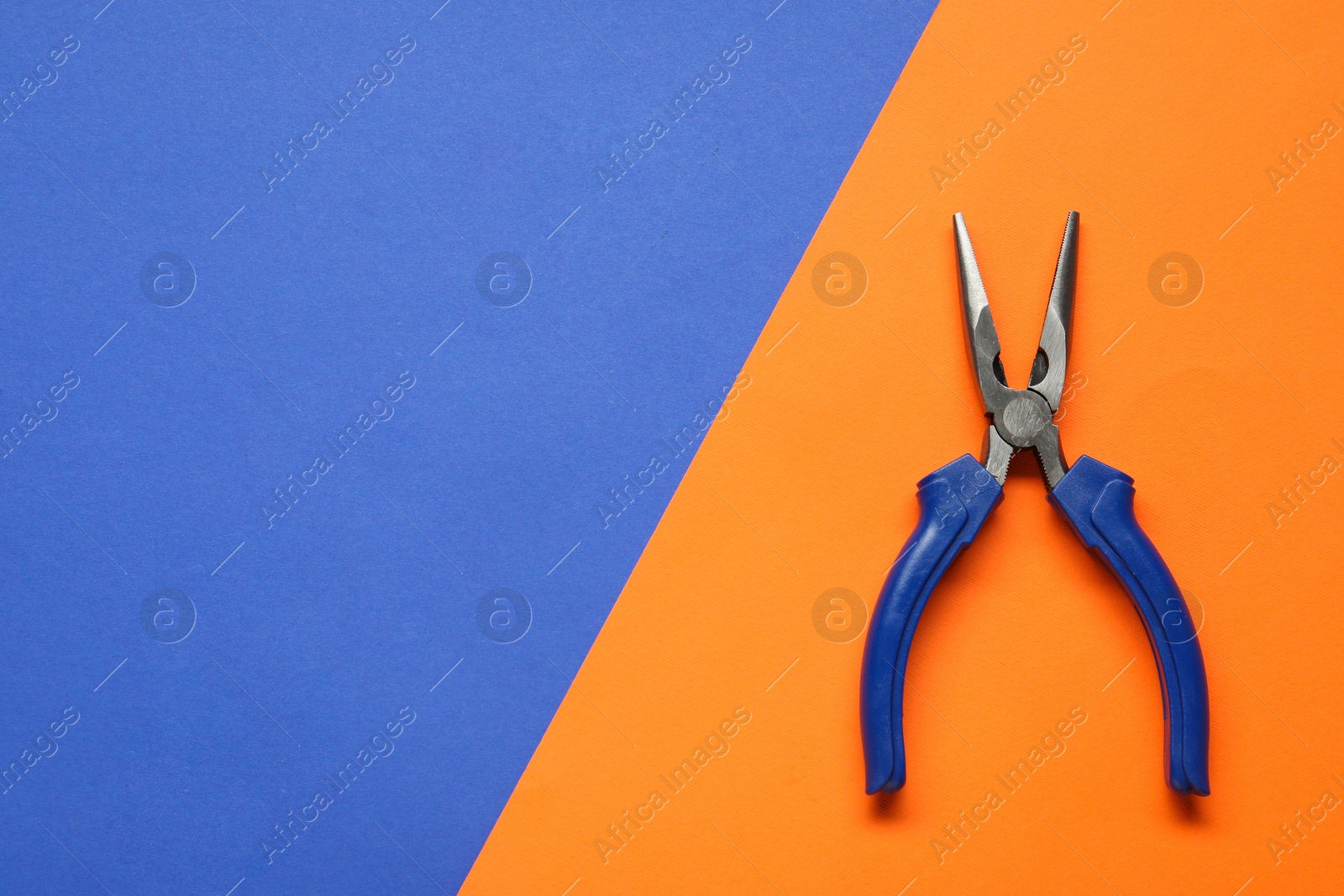 Photo of Needle nose pliers on color background, top view. Space for text