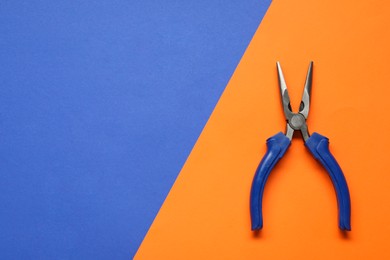 Photo of Needle nose pliers on color background, top view. Space for text