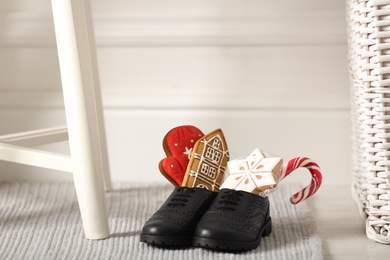 Photo of Sweets in child's shoes indoors, space for text. St. Nicholas Day tradition