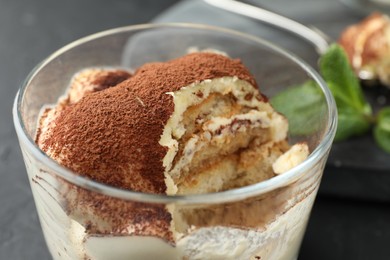 Photo of Delicious tiramisu in glass on table, closeup