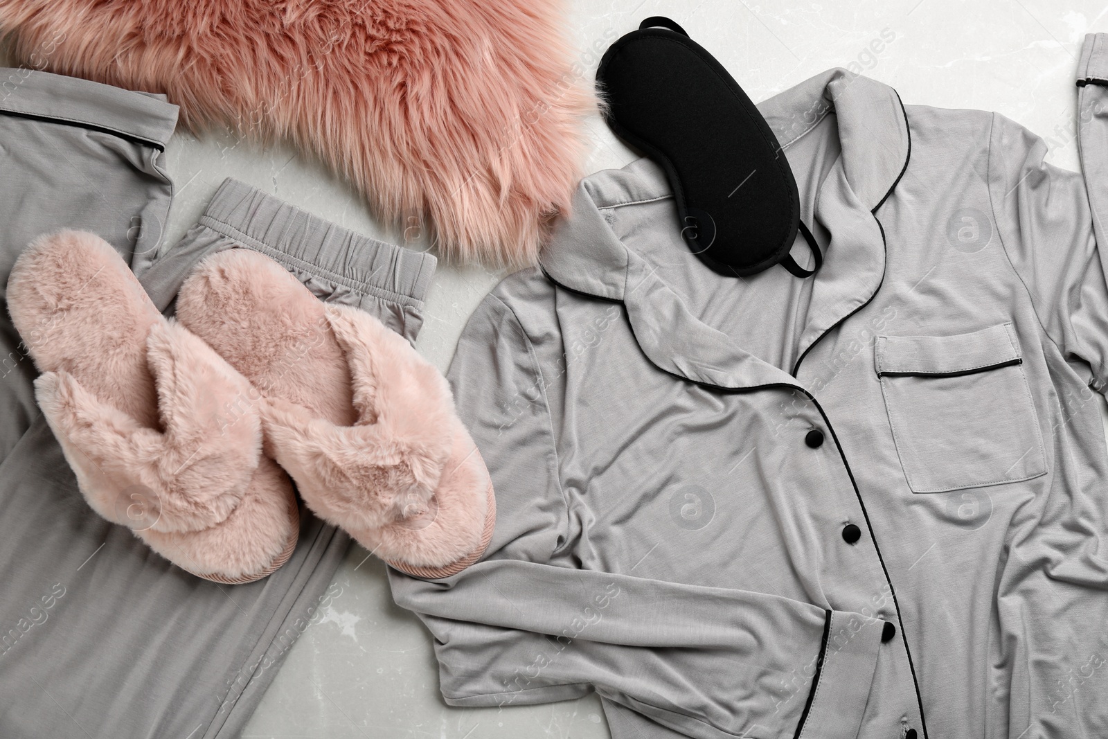 Photo of Flat lay composition with fluffy slippers and pajamas on grey background. Comfortable home outfit