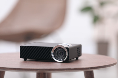 Photo of Modern video projector on wooden table indoors