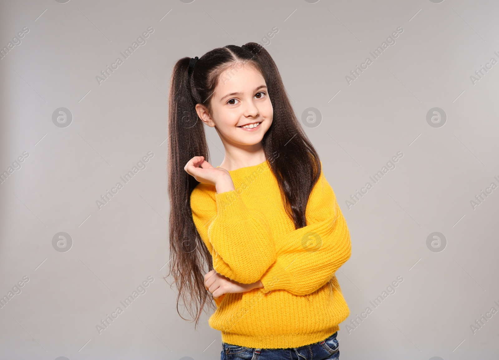 Photo of Portrait of little girl posing on grey background