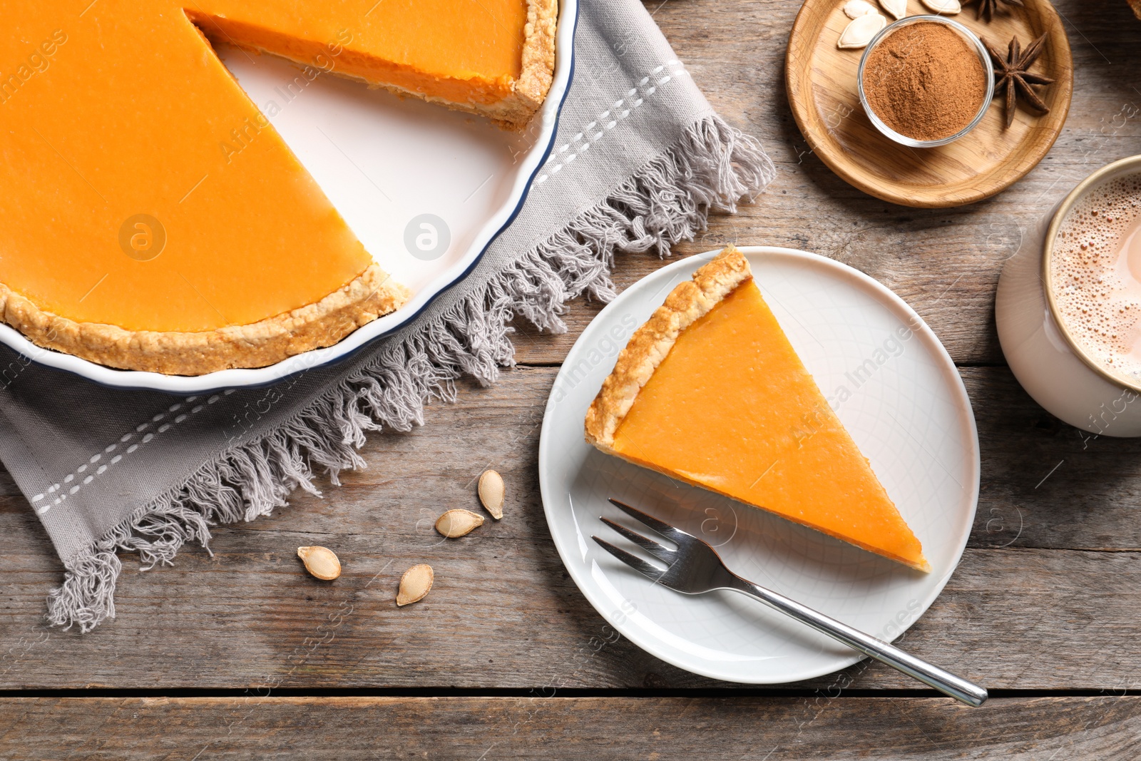 Photo of Flat lay composition with piece of fresh delicious homemade pumpkin pie on wooden background