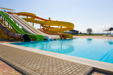 Image of Colorful slides near swimming pool  in water park