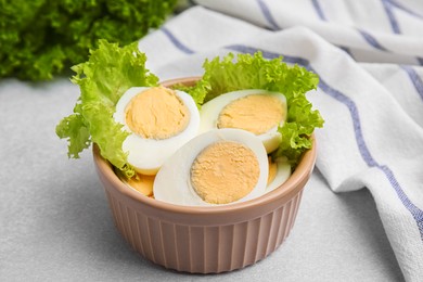 Photo of Fresh hard boiled eggs and lettuce on light grey table