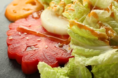 Photo of Slate plate of delicious salad with Chinese cabbage, tomatoes and onion, closeup
