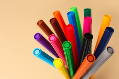 Photo of Many bright markers on beige background, closeup