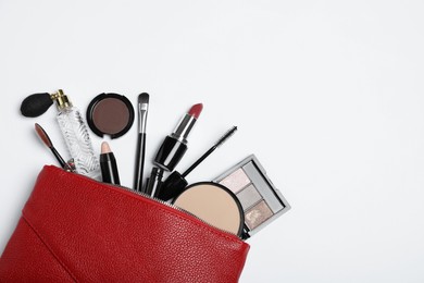 Photo of Cosmetic bag with makeup products and accessories on white background, top view