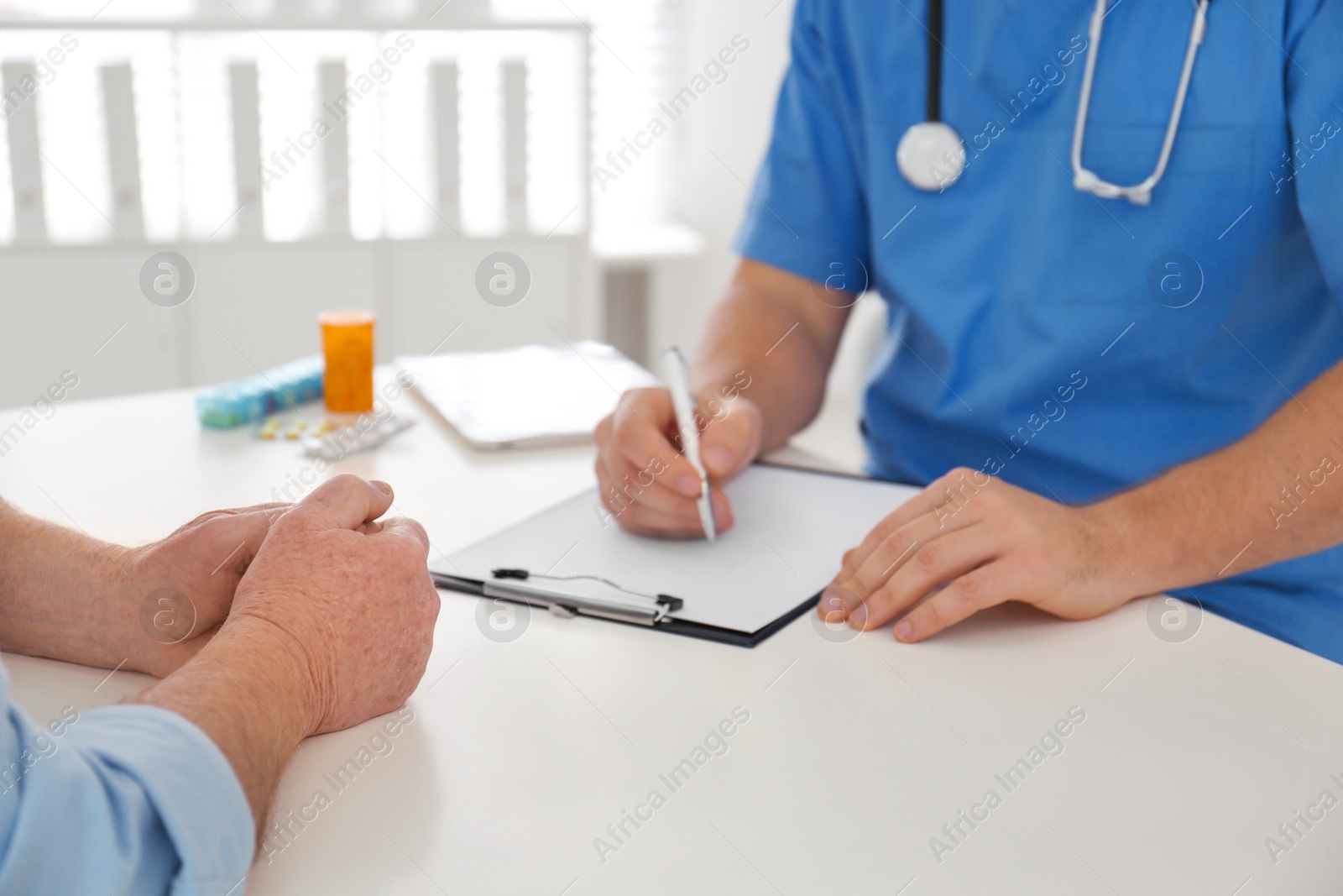 Photo of Professional doctor examining senior patient in office, closeup