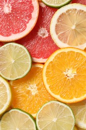 Photo of Different sliced citrus fruits as background, top view