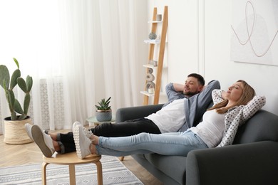 Photo of Couple relaxing on sofa in living room