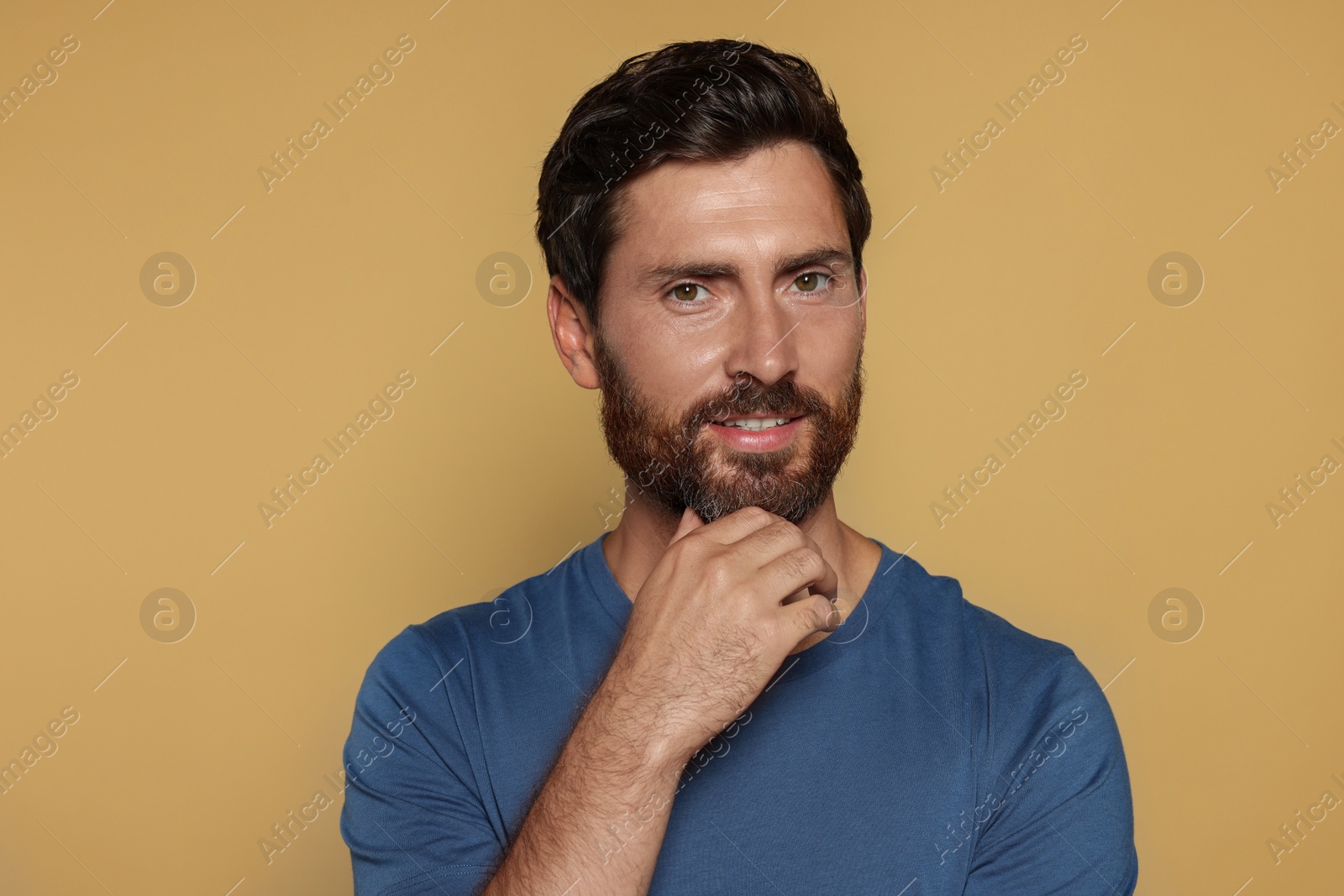 Photo of Portrait of handsome bearded man on yellow background