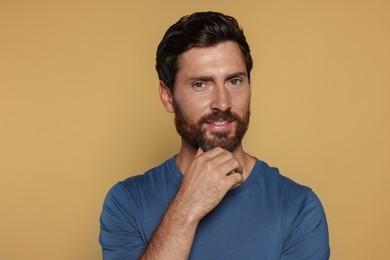 Portrait of handsome bearded man on yellow background