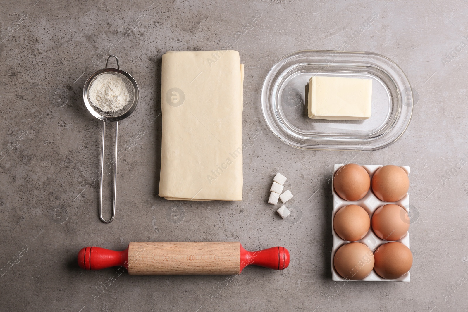 Photo of Flat lay composition with fresh dough on grey table. Puff pastry