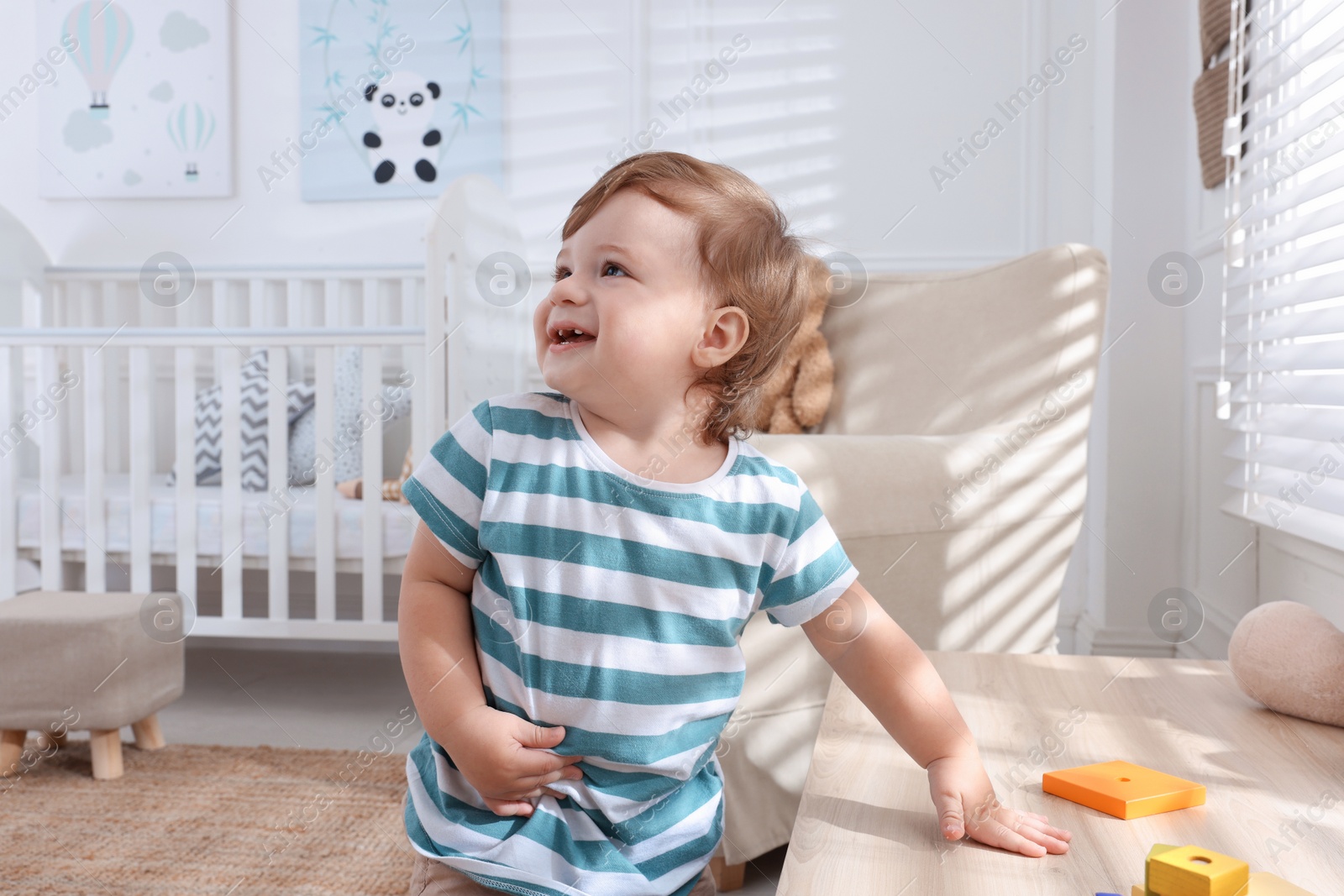 Photo of Cute little boy playing with toys in room at home