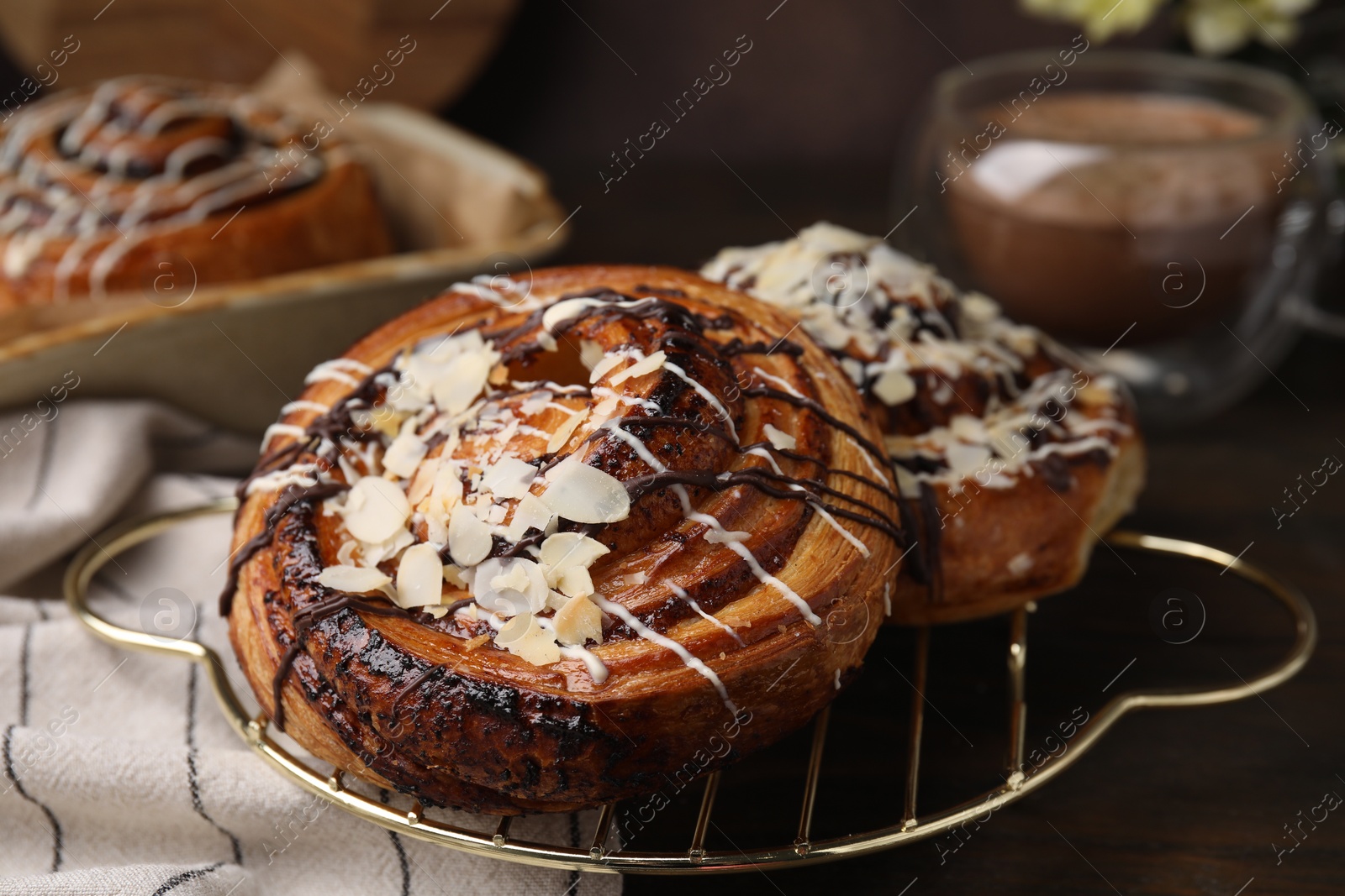 Photo of Delicious rolls with toppings and almond on wooden table, closeup. Sweet buns