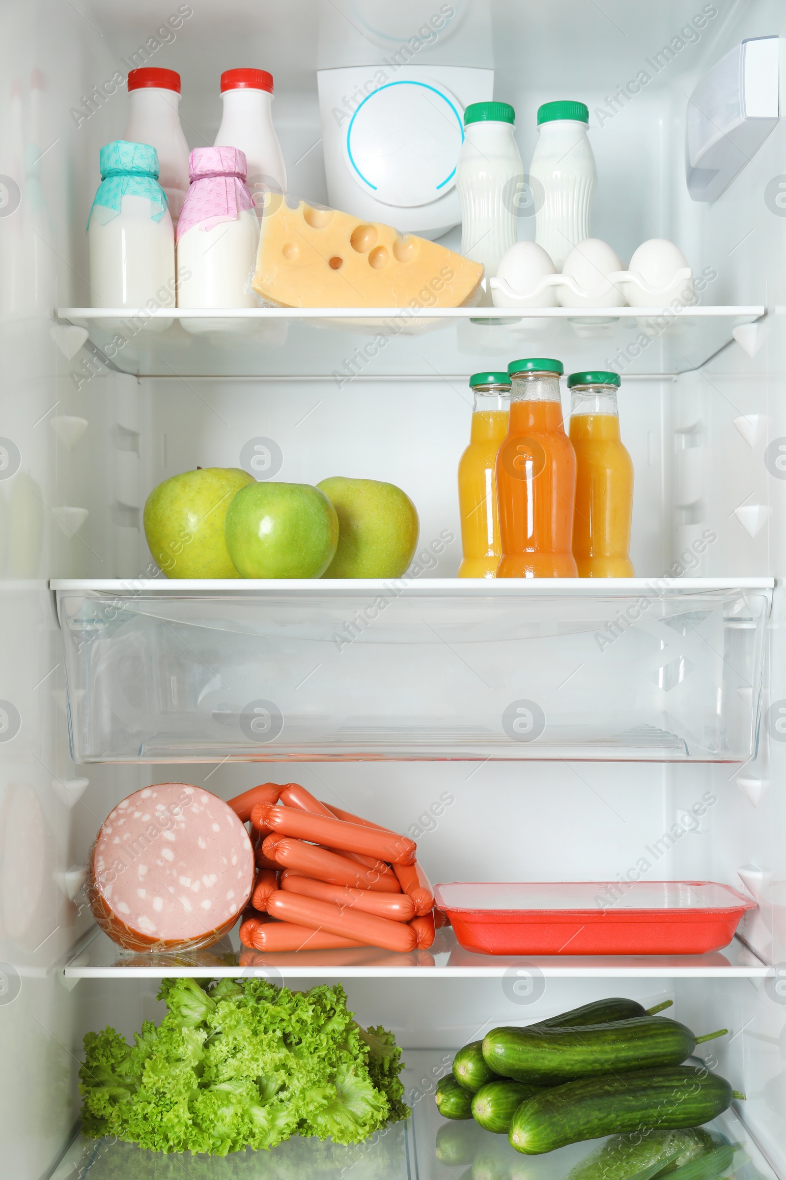 Photo of Open refrigerator with many different products, closeup