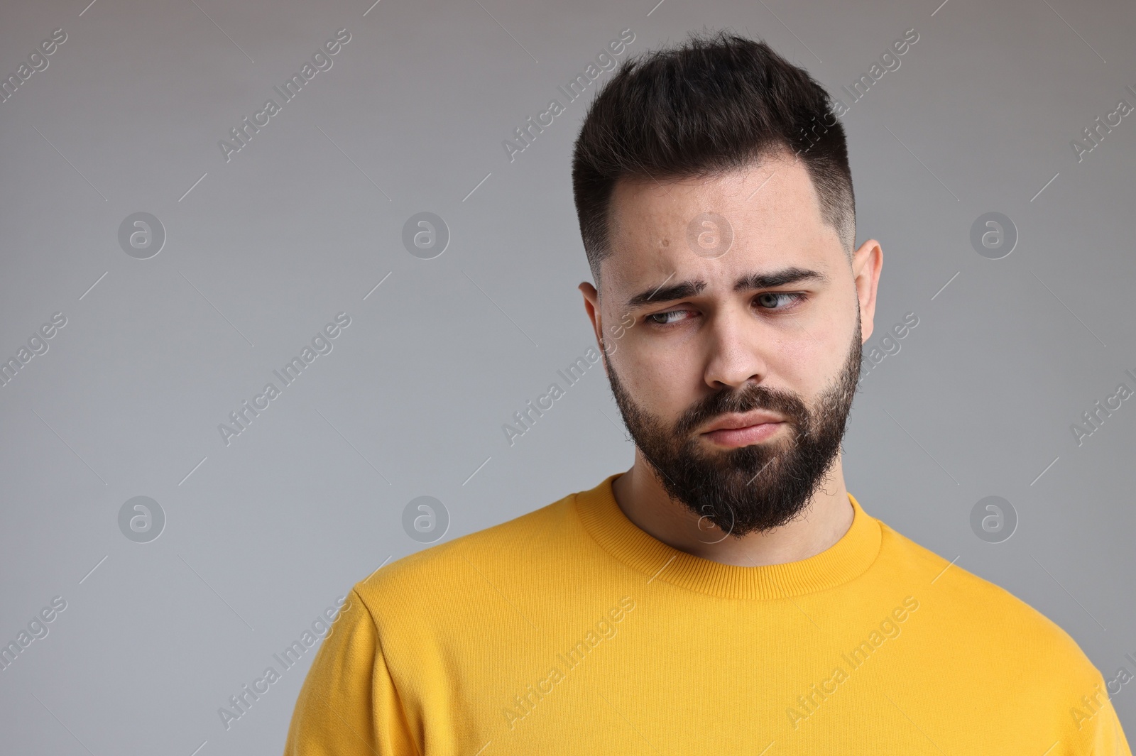 Photo of Portrait of sad man on light grey background, space for text