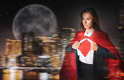 Image of Confident businesswoman wearing superhero costume under suit and beautiful cityscape in night on background
