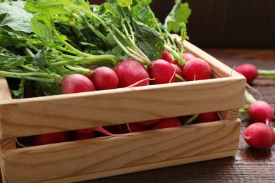 Crate with fresh ripe radish on wooden table, closeup