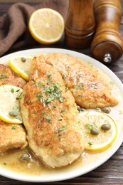 Delicious chicken piccata on wooden table, closeup