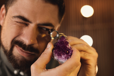 Jeweler working with gemstone on blurred background, closeup