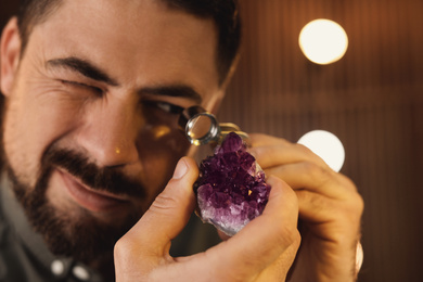 Photo of Jeweler working with gemstone on blurred background, closeup