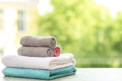 Photo of Stack of clean towels on table against blurred background. Space for text