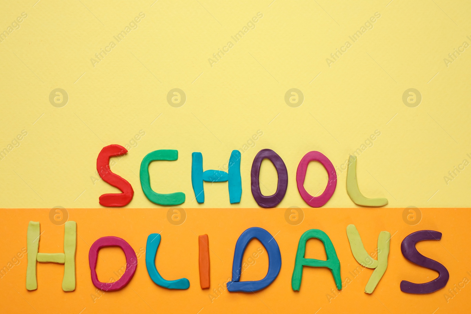 Photo of Phrase School Holidays made of modeling clay on color background, top view