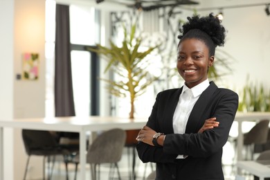 Photo of Happy woman with crossed arms in office, space for text. Lawyer, businesswoman, accountant or manager