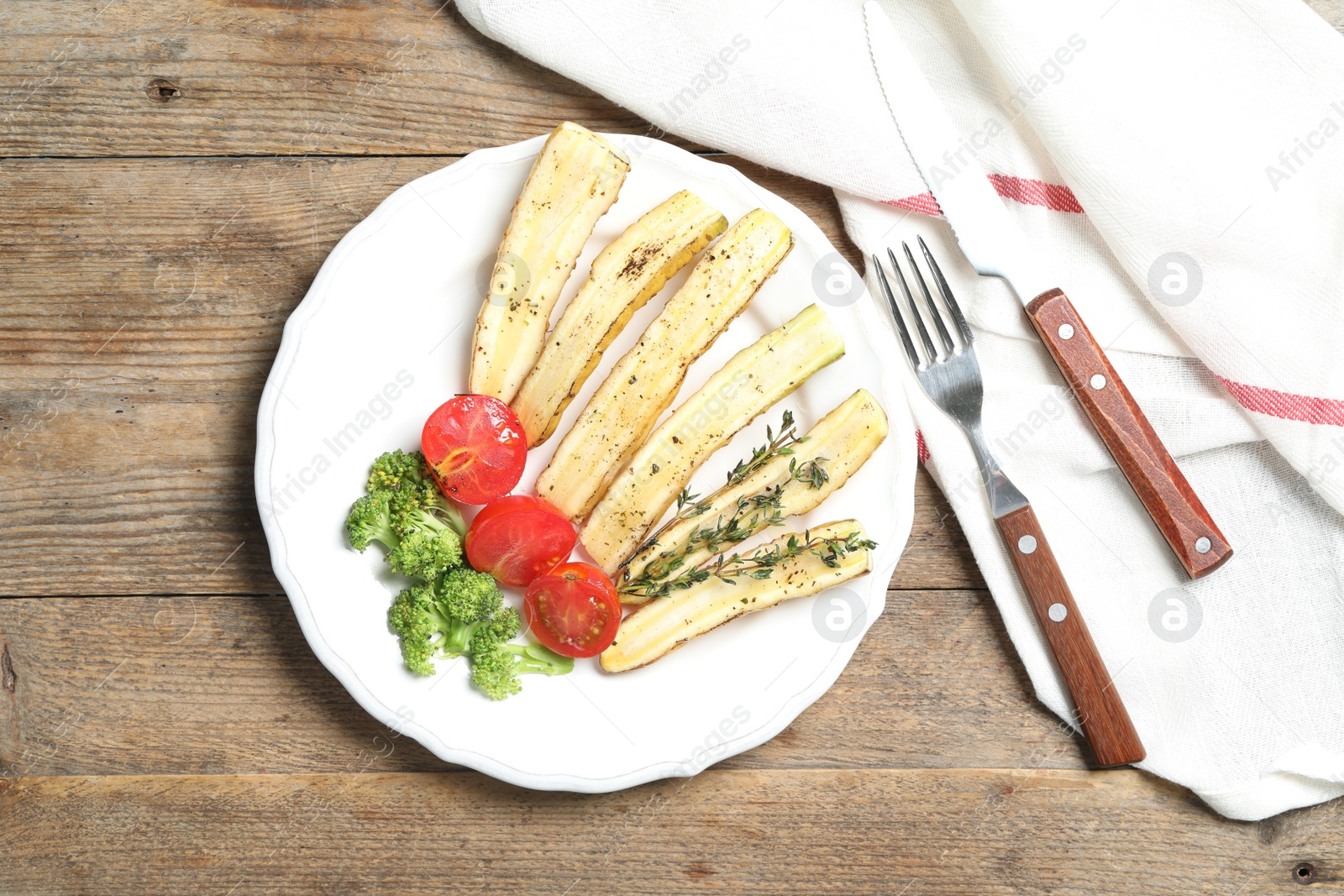 Photo of Baked white carrot served on wooden table, flat lay