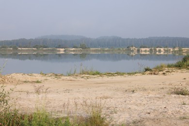 Photo of Picturesque view of lake and sandy beach on summer day