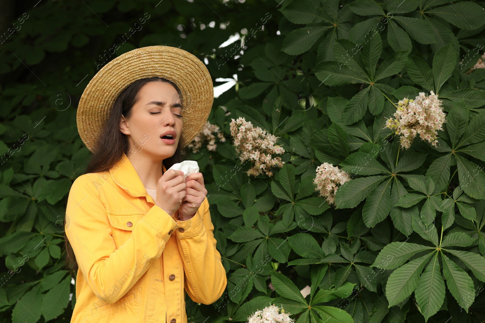 Photo of Woman suffering from seasonal spring allergy near tree in park