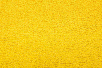 Photo of Texture of yellow leather as background, closeup