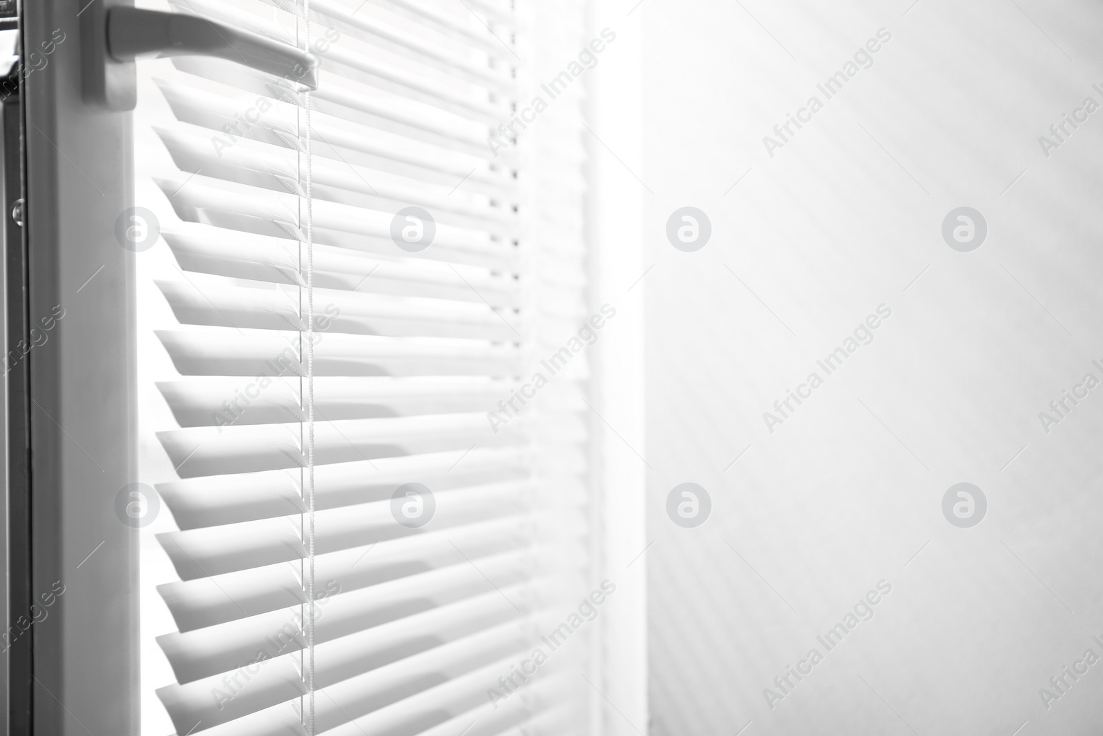 Photo of Window with closed horizontal blinds indoors. Space for text