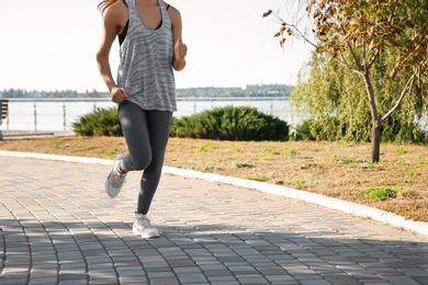 Photo of Sporty woman running outdoors on sunny morning