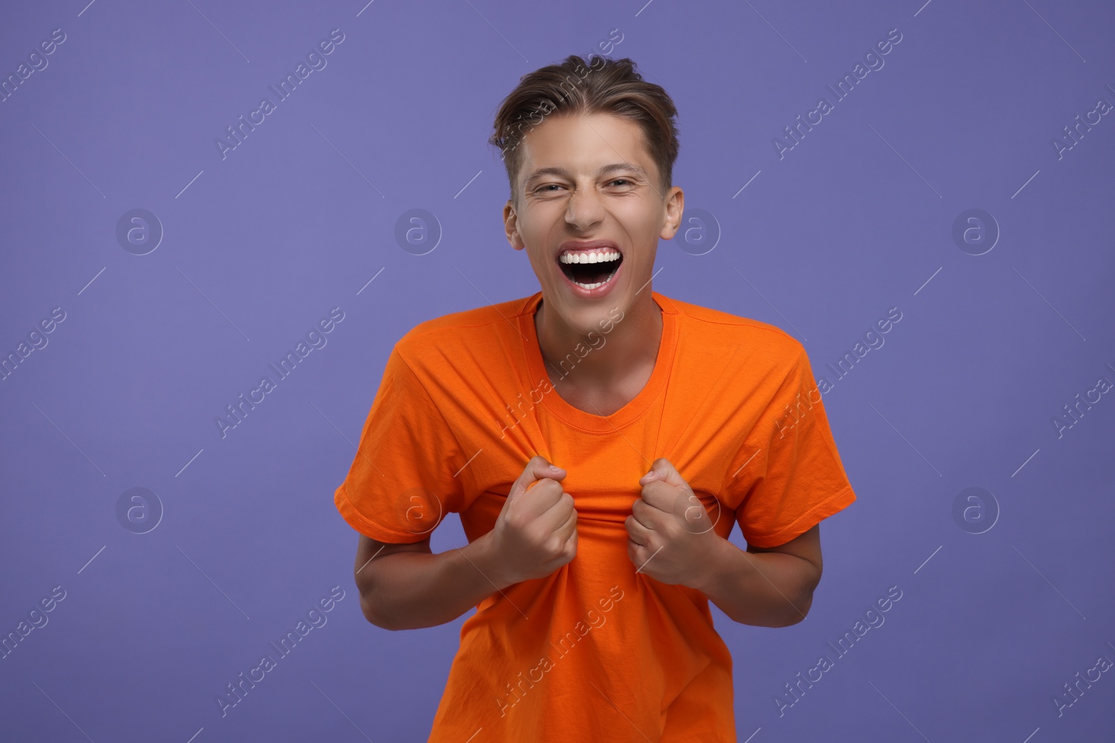 Photo of Emotional sports fan celebrating on purple background