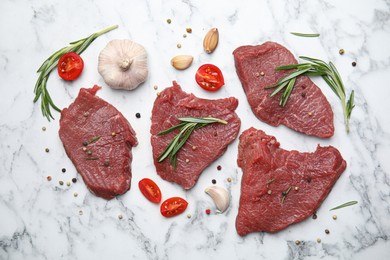 Photo of Fresh raw meat steaks and spices on white marble table, flat lay